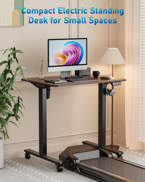 32" Small Electric Rolling Standing Desk Adjustable Height, Mobile Sit Stand up Desk with Lockable Casters for Home Office & Computer Workstation, Splice Board, 2 Hooks, Black Frame/Walnut Top
